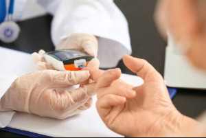 Enfermera a domicilio monitorea los niveles de glucosa en sangre en paciente diabético. 